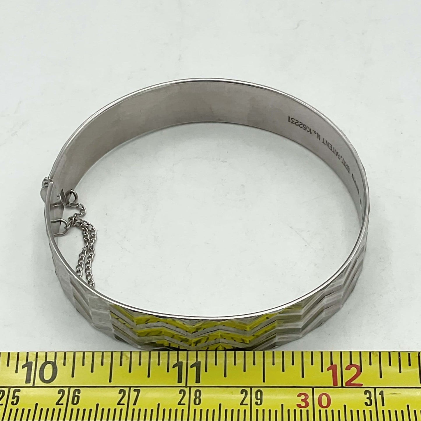 Zig zag design bracelet next to tape measure showing width as appropriately 6.5cm