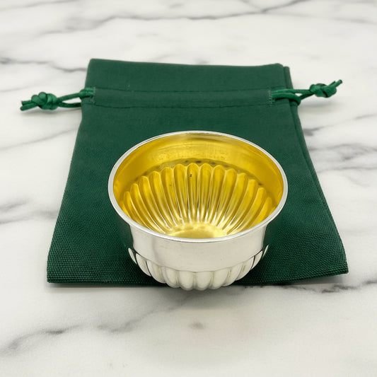 Glided silver Victorian salt on a green gift bag and white background