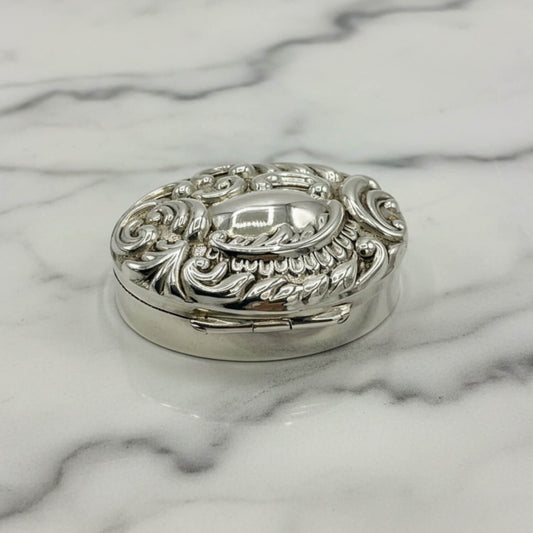 Decorative silver pill box on a marble surface