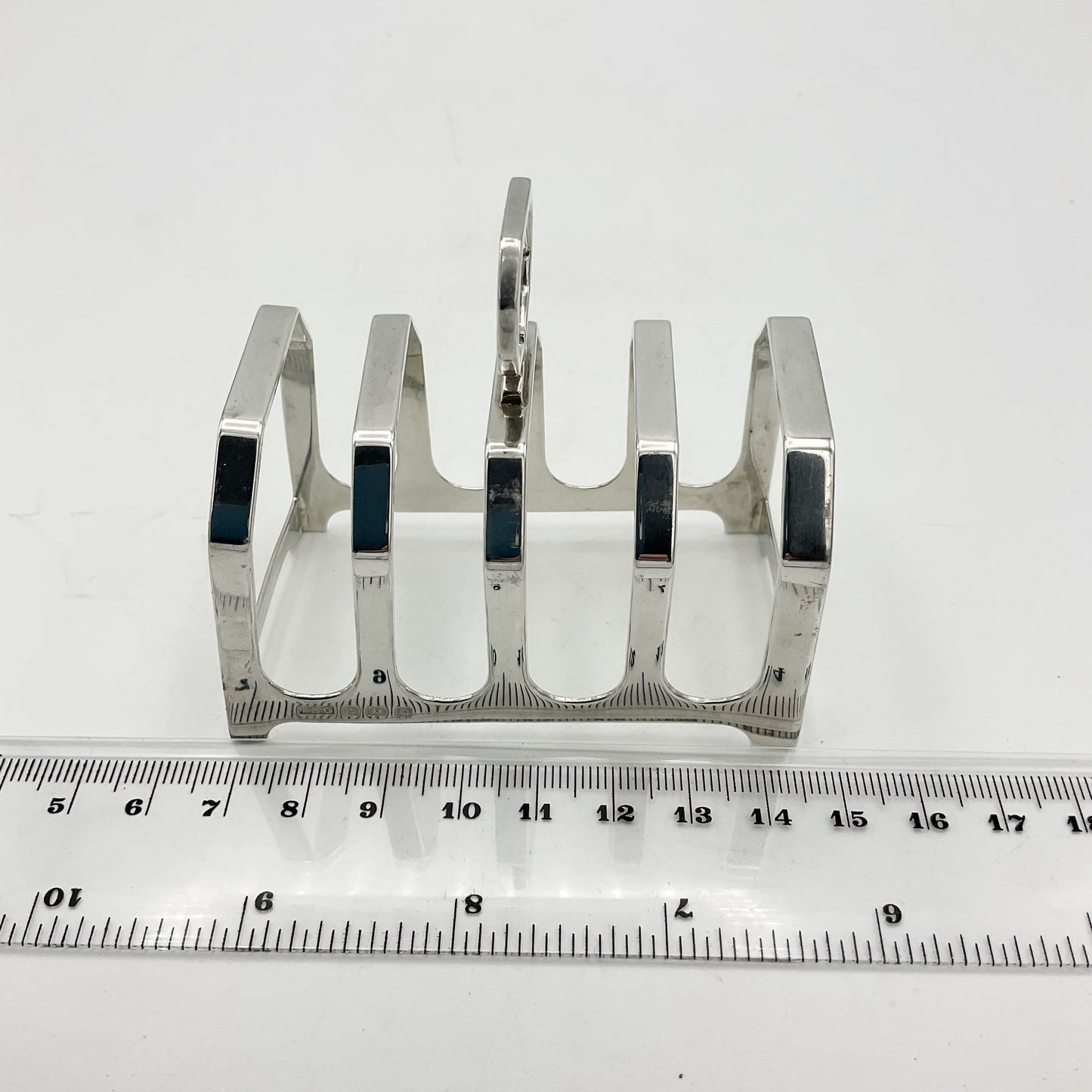 Antique Silver Toast Rack next to a ruler showing it’s length as 7.5cm
