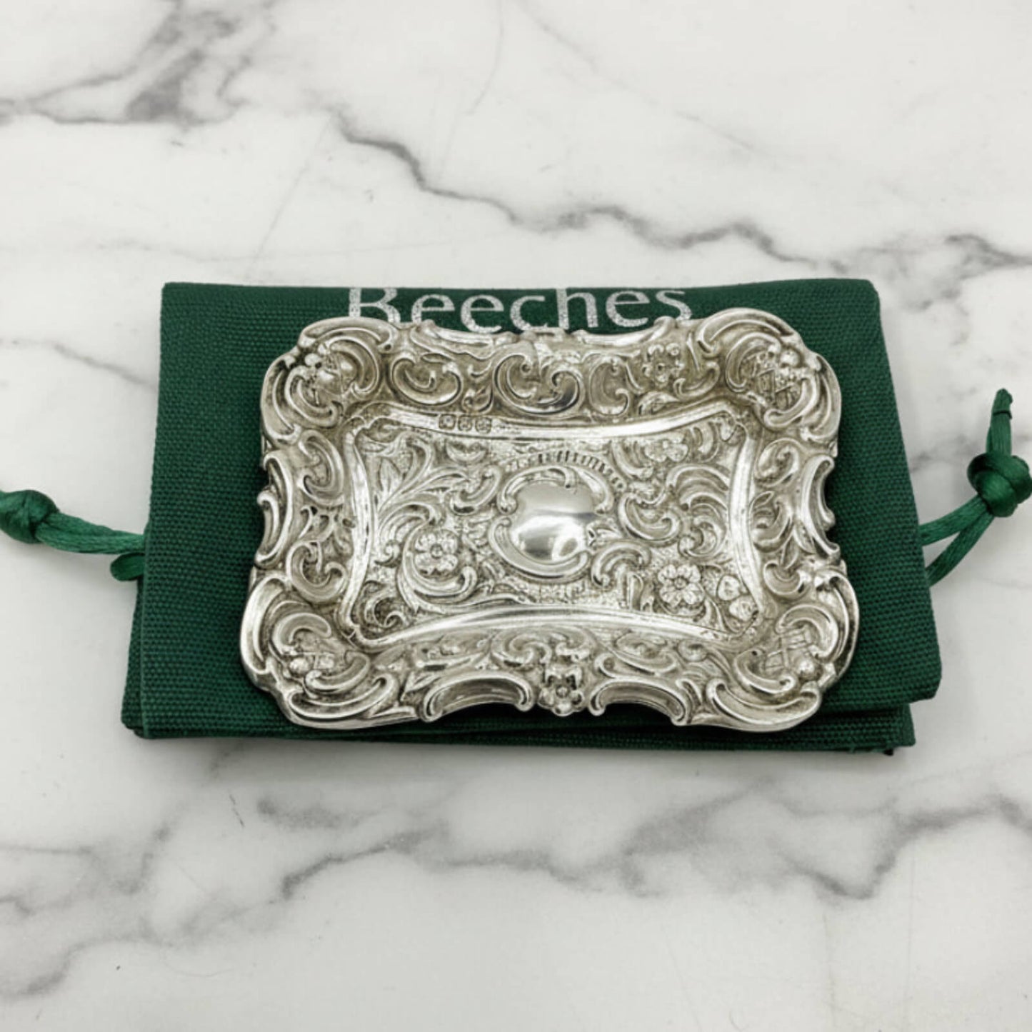 Antique Small Repousse Silver Tray on a green bag and marble surface