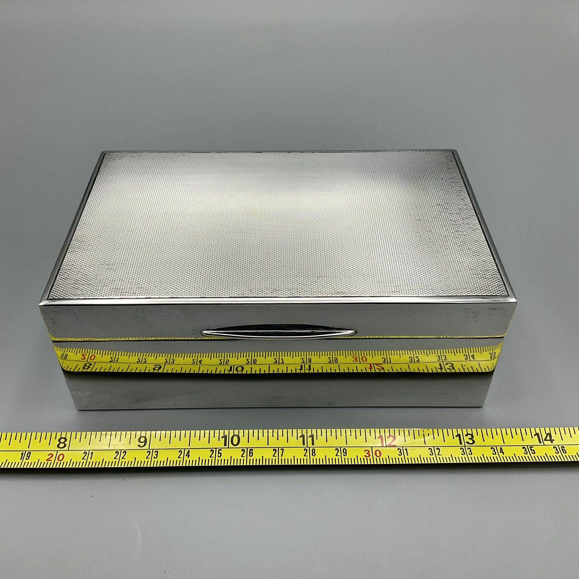 1960s Silver cigarette box next to tape measure showing width as approx 14cm