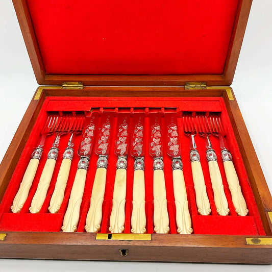 Antique silver plated dessert knives and forks with bone handles in a red lined wooden presentation box