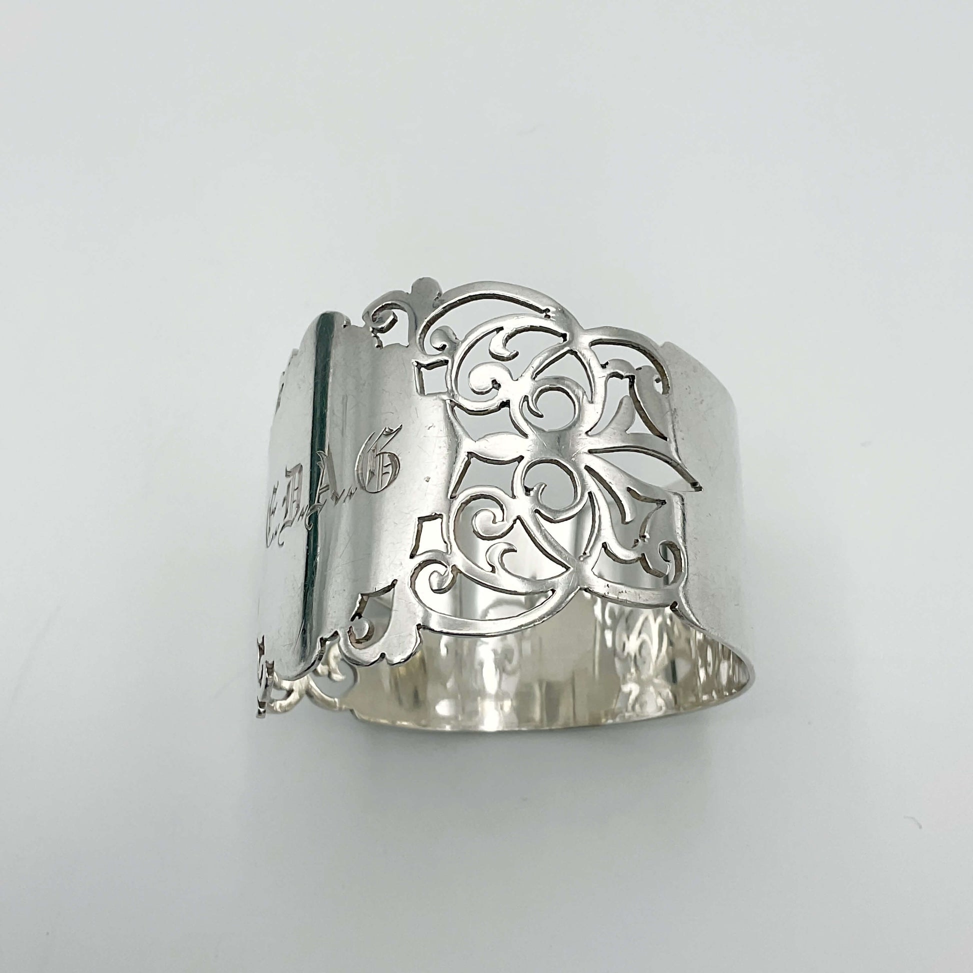 Shiny napkin ring with elaborate sides and EDAG in the centre on a plain background 