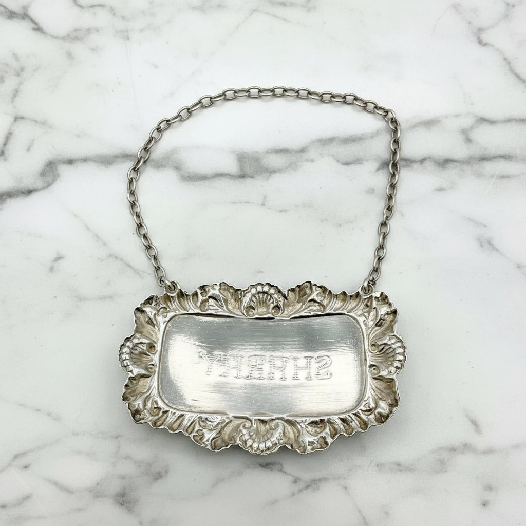 Back of A shiny Sherry decanter label on a marble background.
