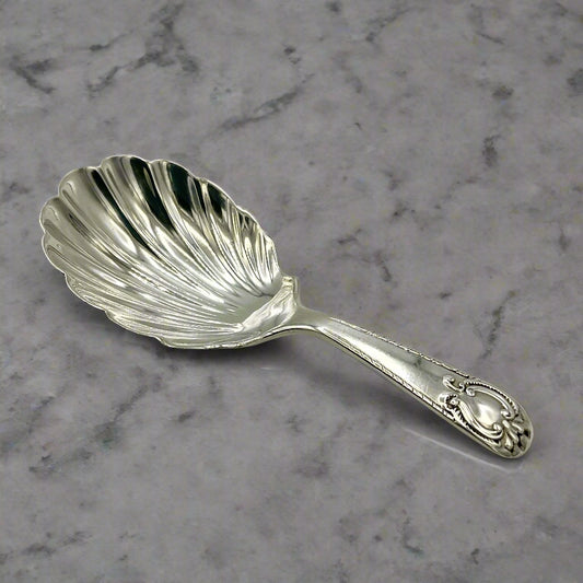 Silver tea caddy spoon on a grey marble worktop