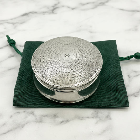 Beautiful antique silver pill box with an Art Deco lid on a green gift bag