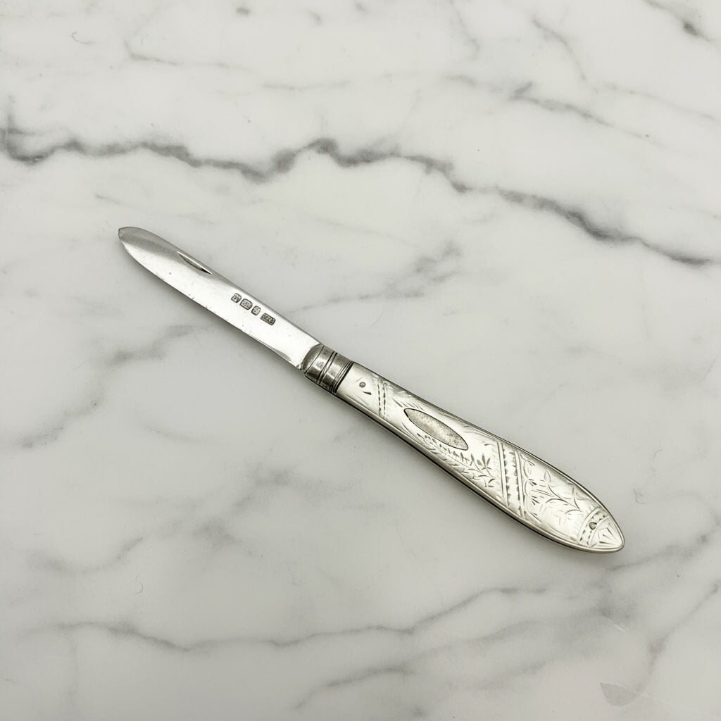 Decorative silver knife on a marble surface