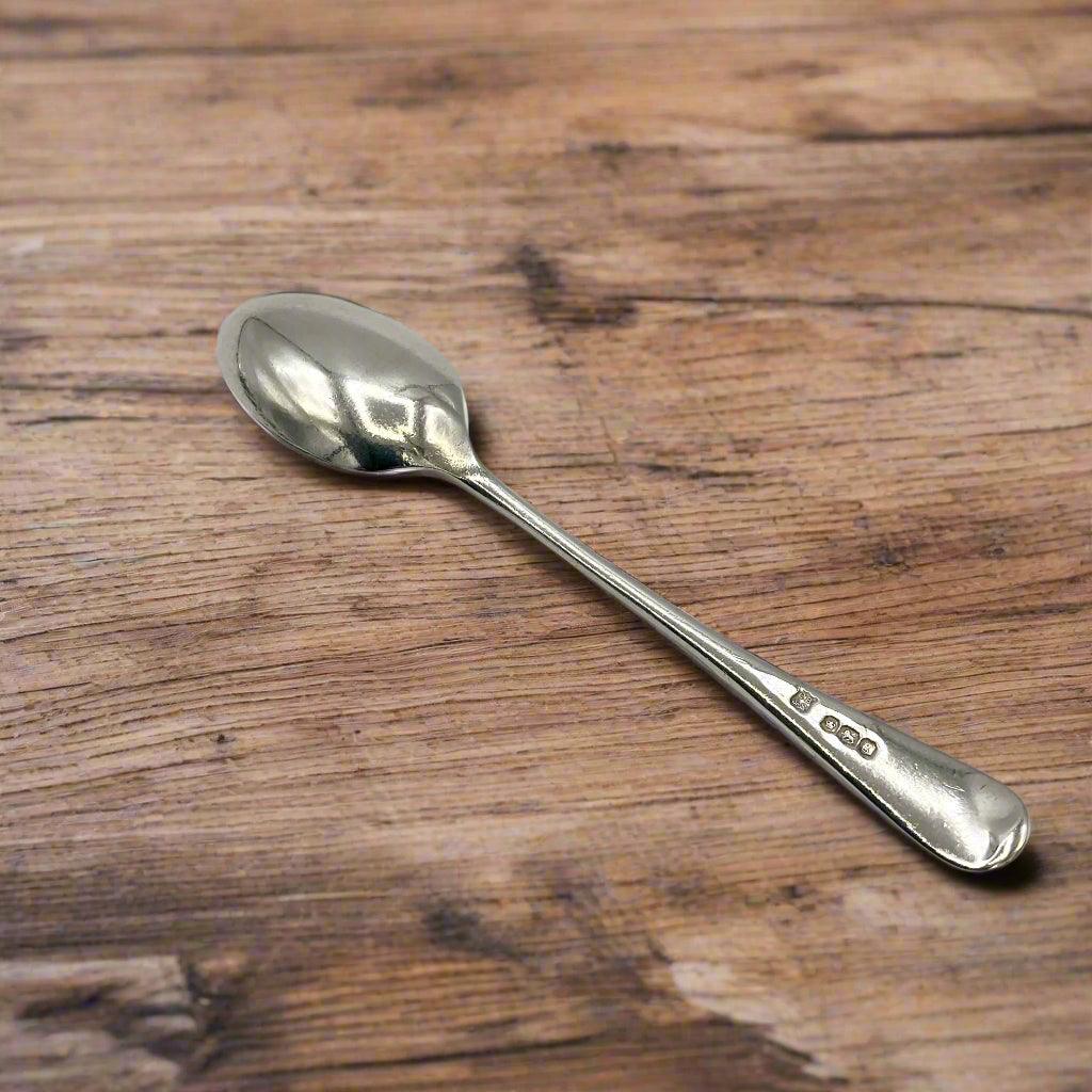 Back of antique silver spoon on a wooden table
