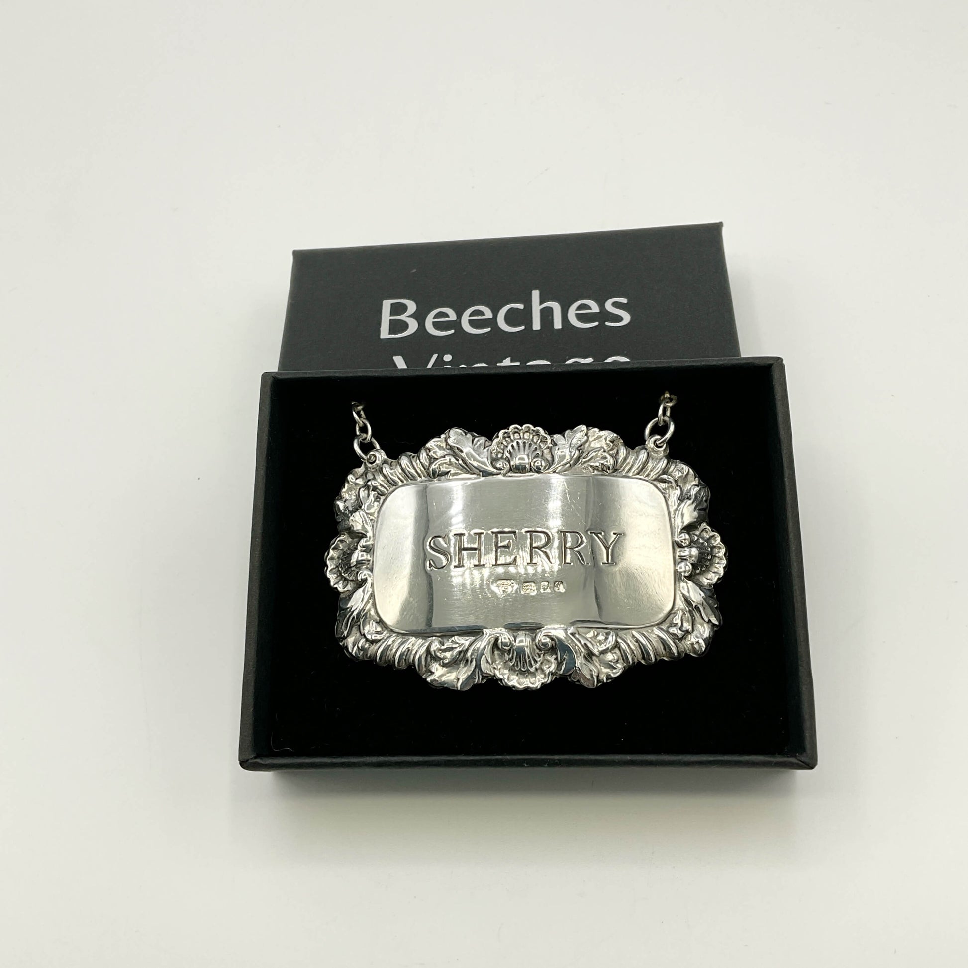 Silver Sherry decanter label in  a black presentation box with a white background