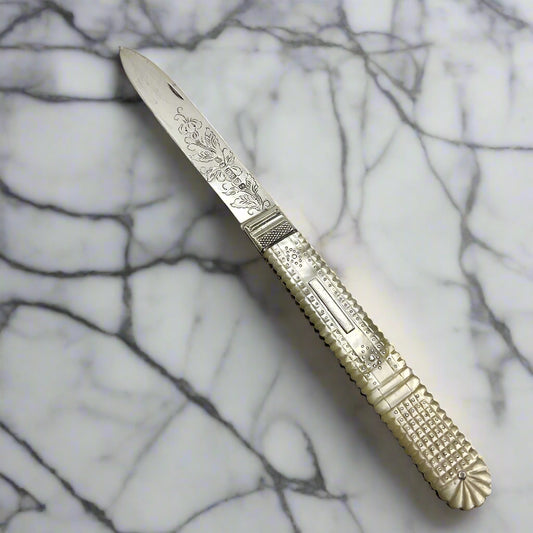 Antique silver fruit knife on a marble worktop