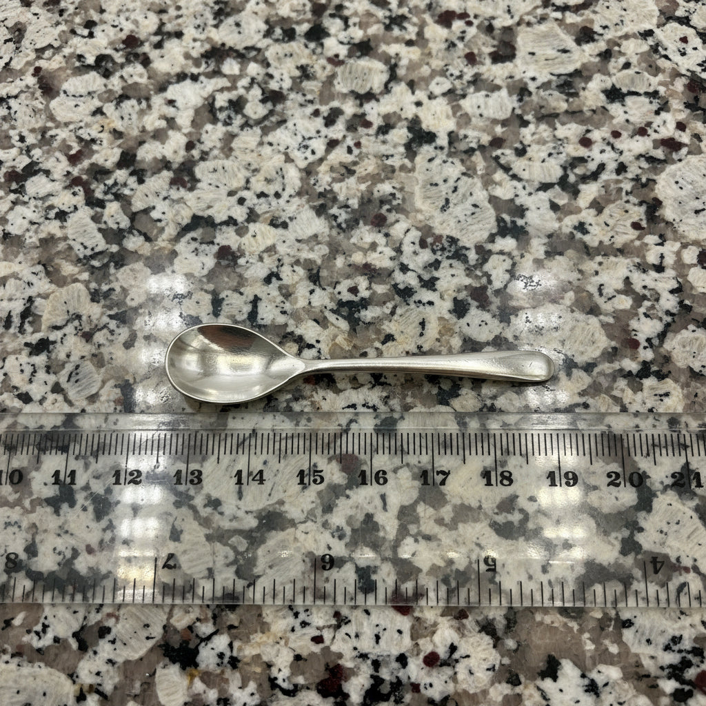 Silver spoon on a granite background with a ruler for scale