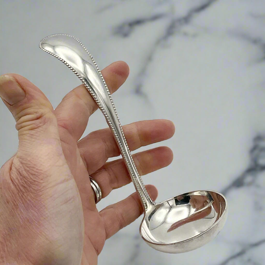 ladle held in a hand with a marble background