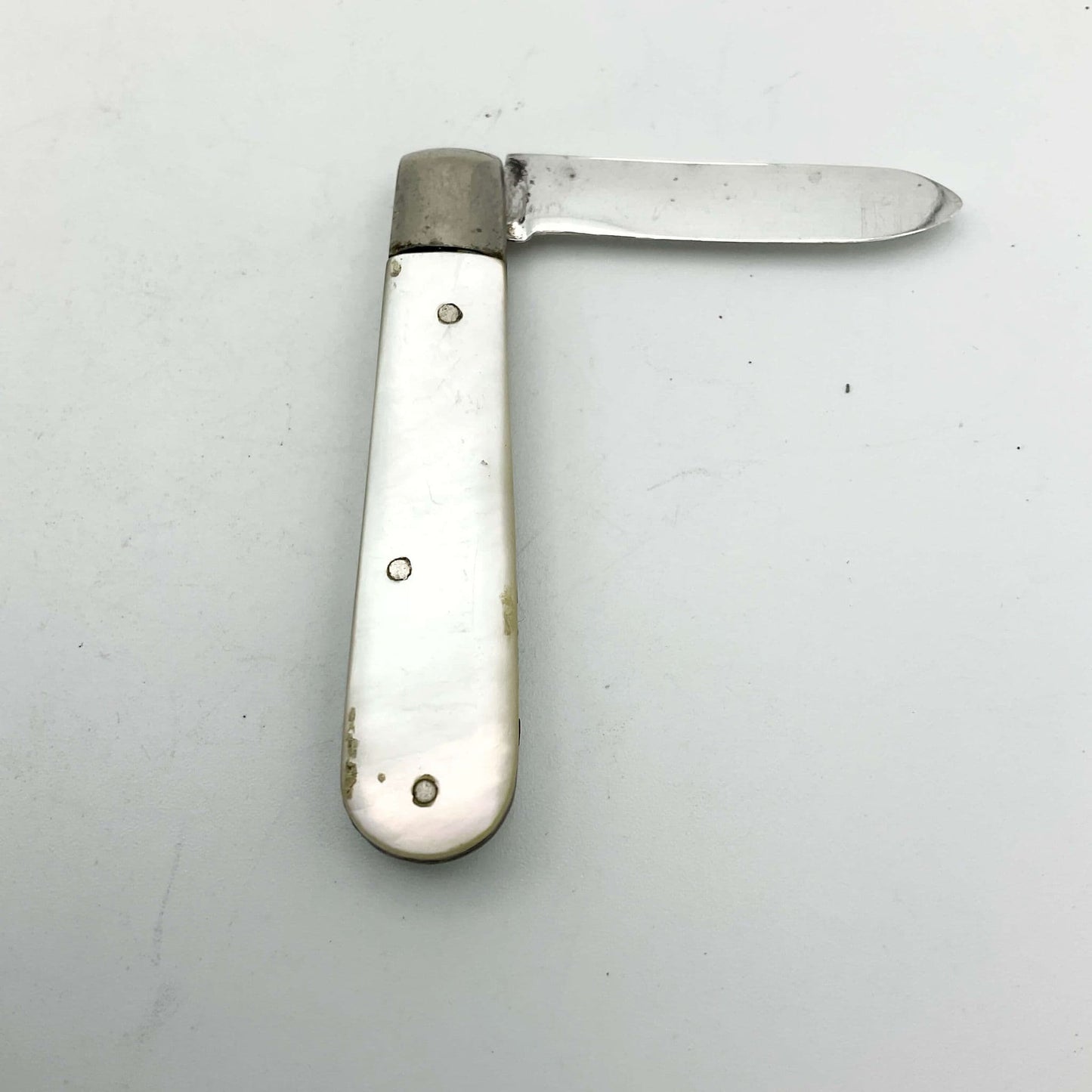 Silver fruit knife with a mother of pearl handle on a white background