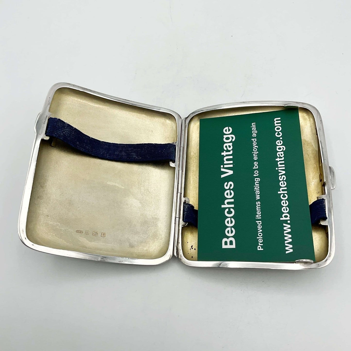 gilded interior of silver cigarette case holding a Beeches Vintage business card