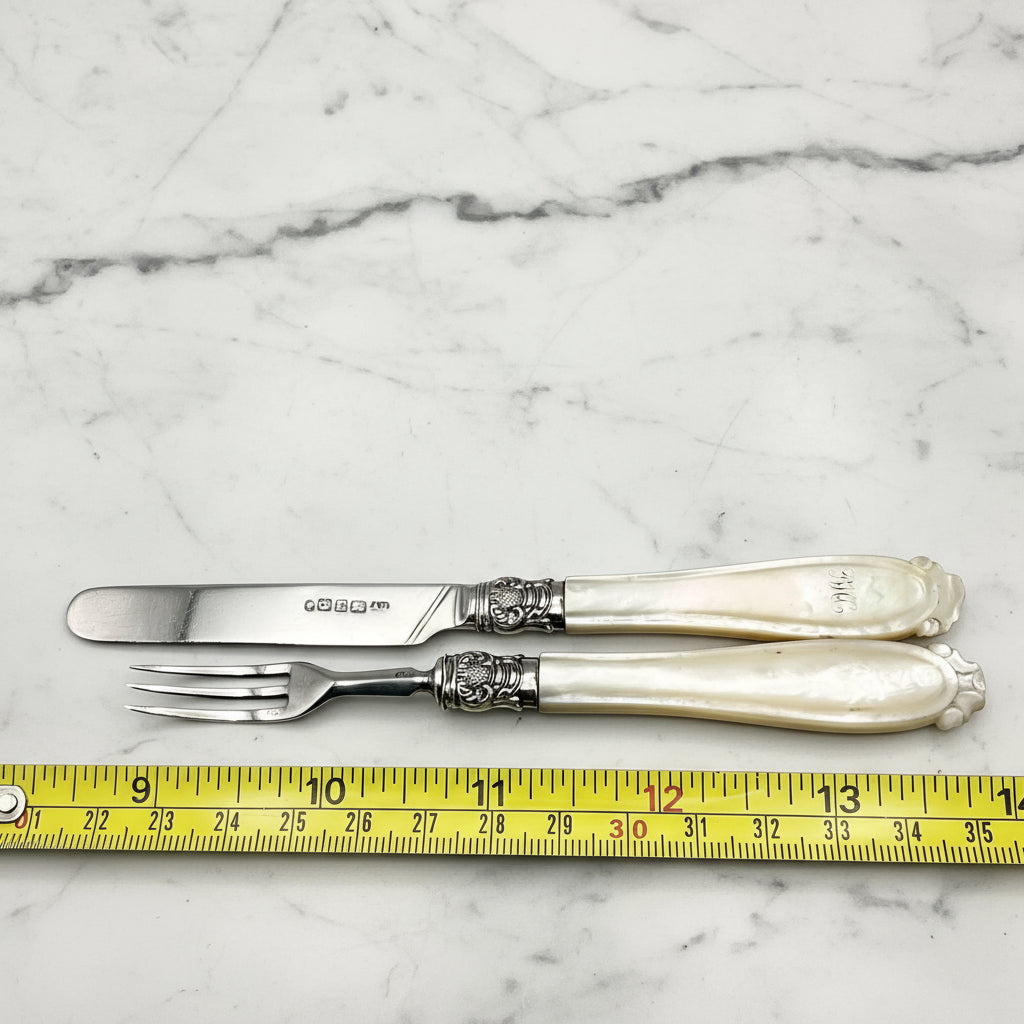 silver cutlery next to a tape measure on a marble worktop