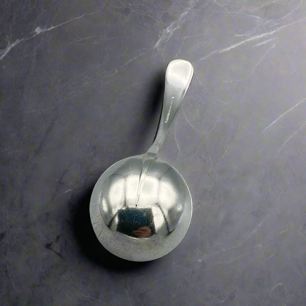 ladle bowl upside down on a dark marble surface