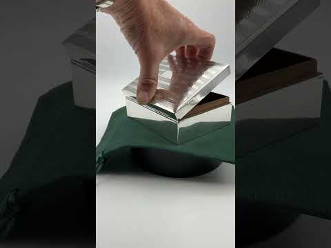 a video short of the silver cigarette box on a green cotton bag on a turntable rotating.