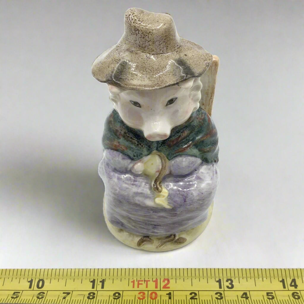 figurine next to tape measure to provide scale on white surface