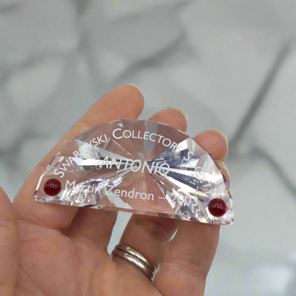 Swarovski Crystal plaque with Antonio on held in a hand with a marble background