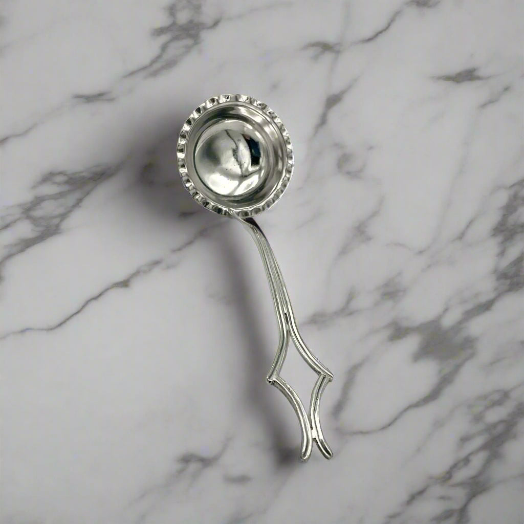 small silver plated ladle on a marble surface