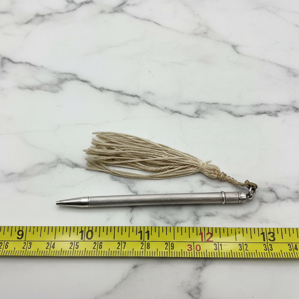 propelling pencil next to a tape measure for scale on a marble worktop