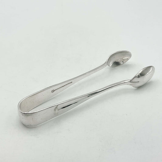 1930s style silver plated sugar tongs with a lined 'rat tail'  design to the arms. The sugar tongs are sitting on a white background.