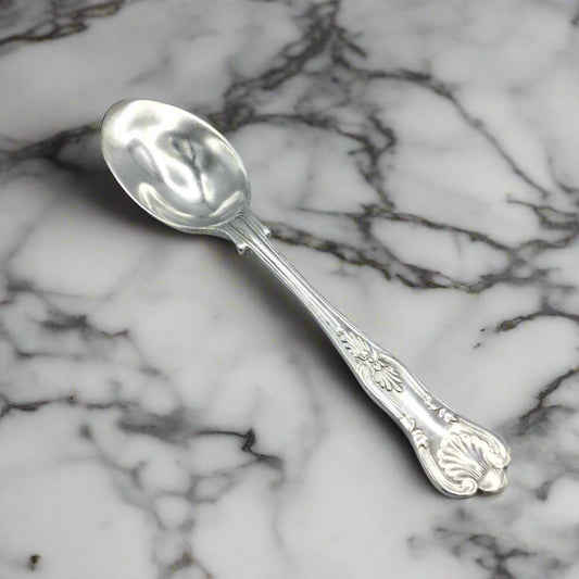 A vintage 1950s silver-plated teaspoon with a lip towards the front, featuring a patterned handle and the Walker & Hall brand marking.
