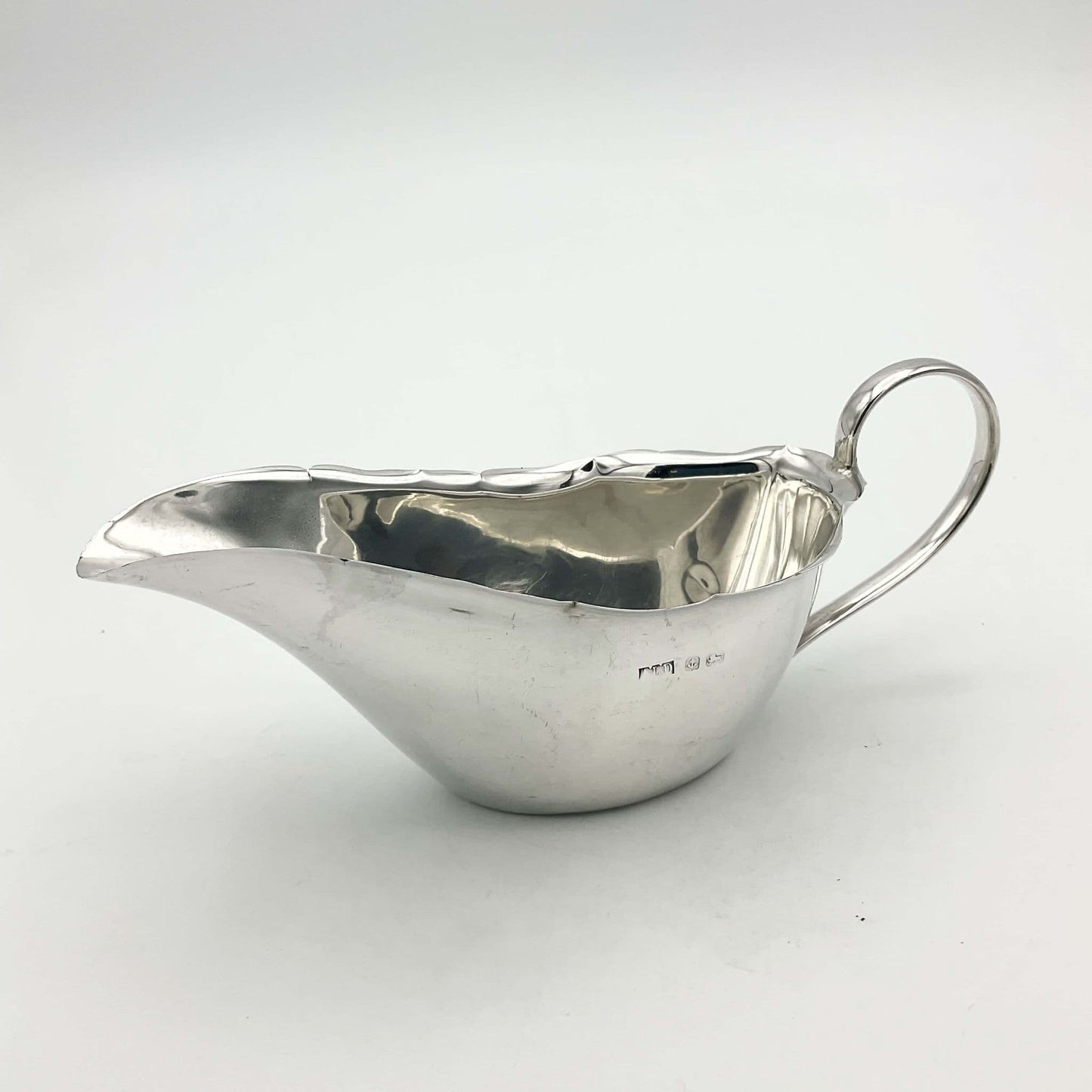 Silver sauce boat with hallmarks on white background 