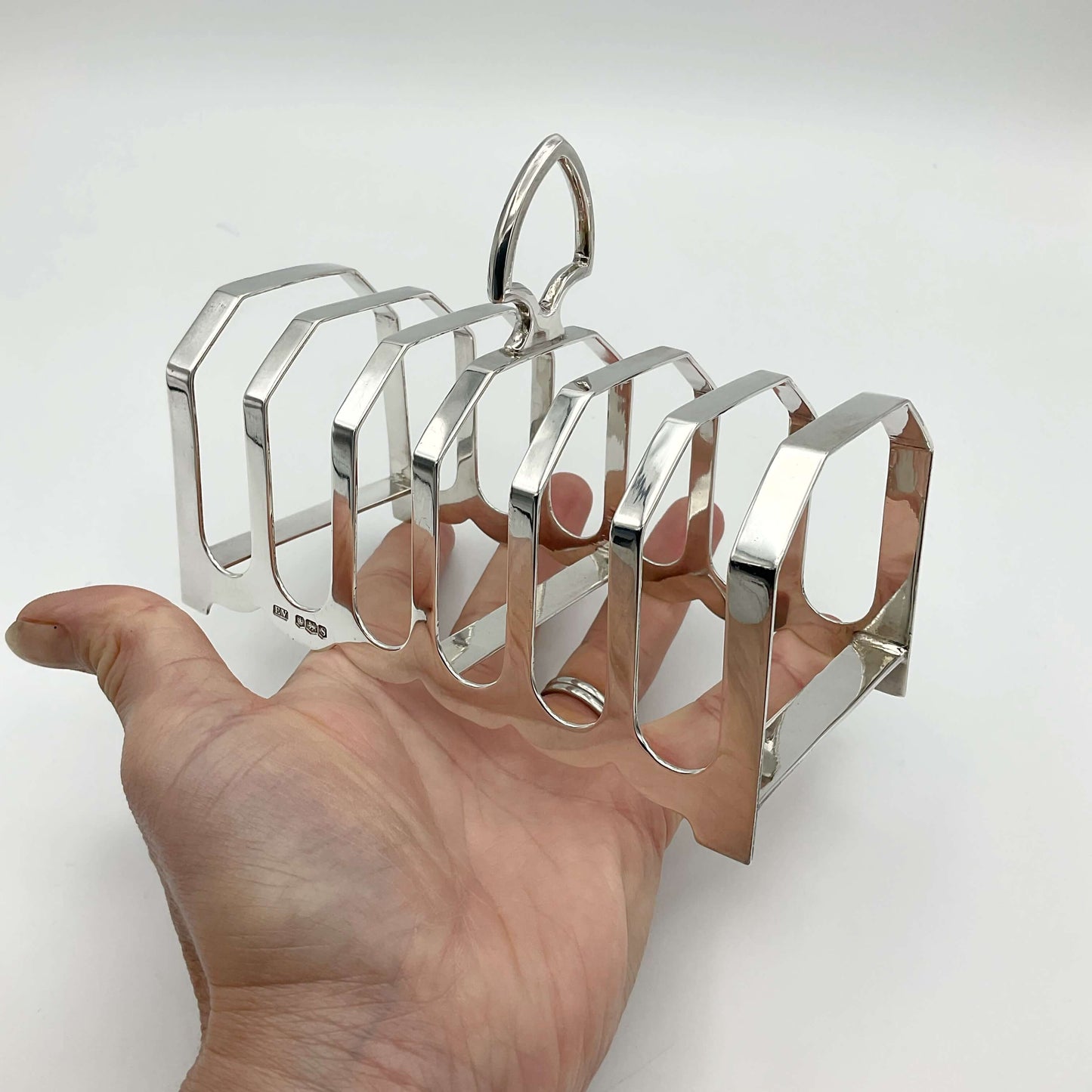 1935 Art Deco Sterling Silver Toast Rack on a hand with a white background