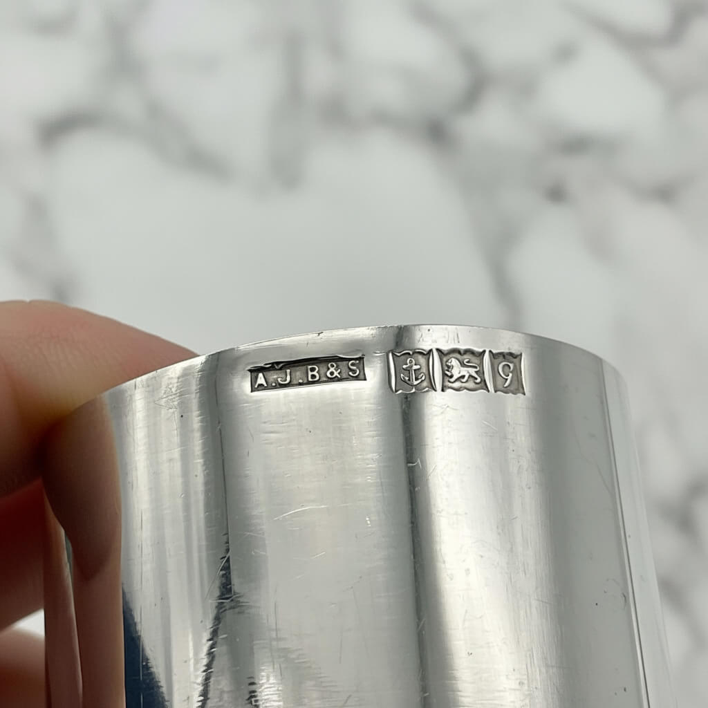 The hallmarks and makers mark on the side of the silver napkin ring