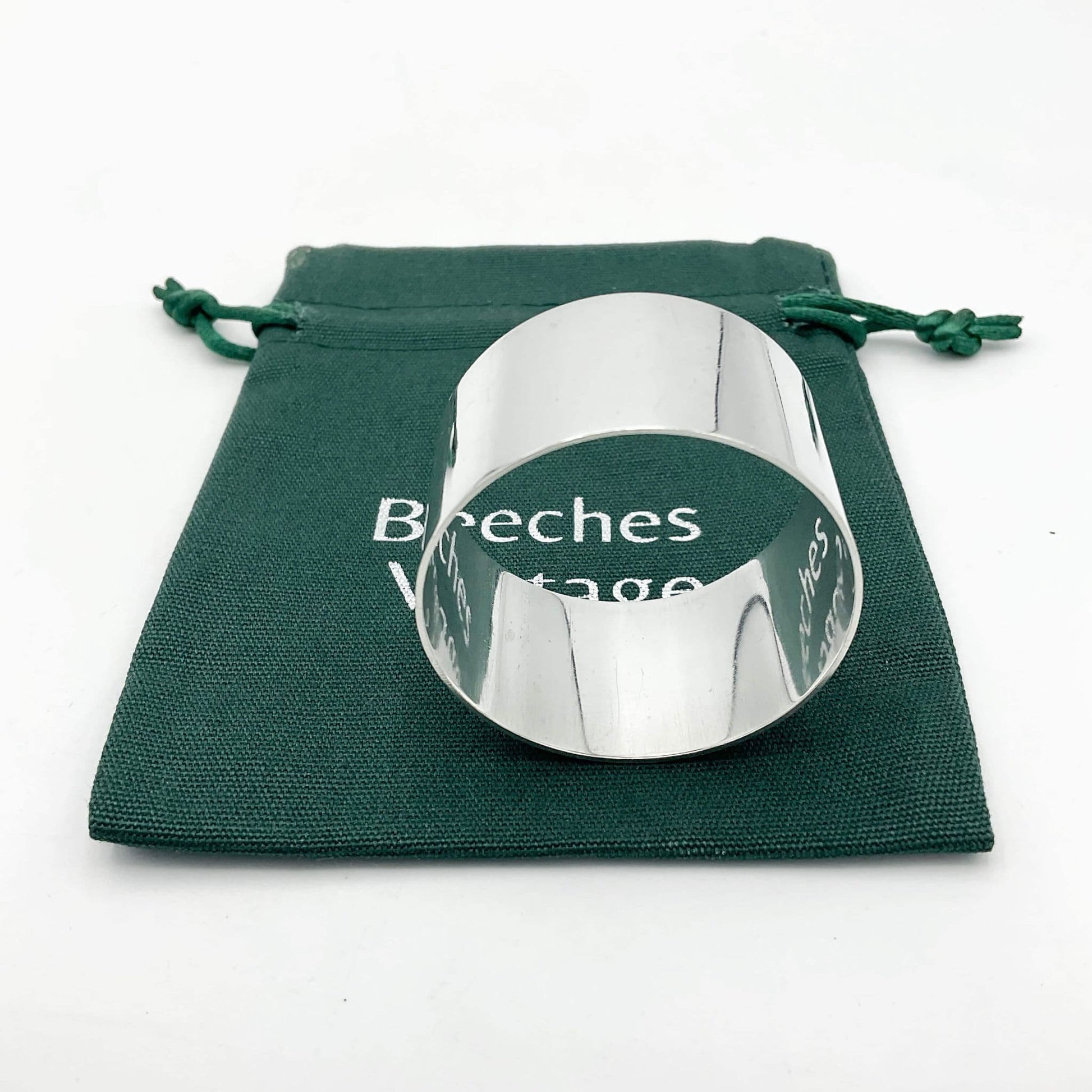 The silver napkin ring sitting on a green gift bag.