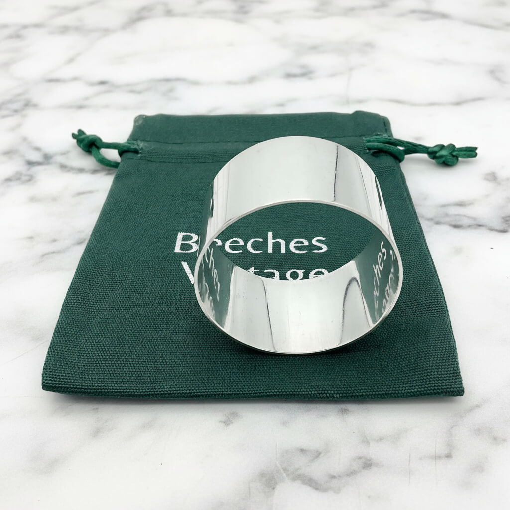 The silver napkin ring sitting on a green gift bag.