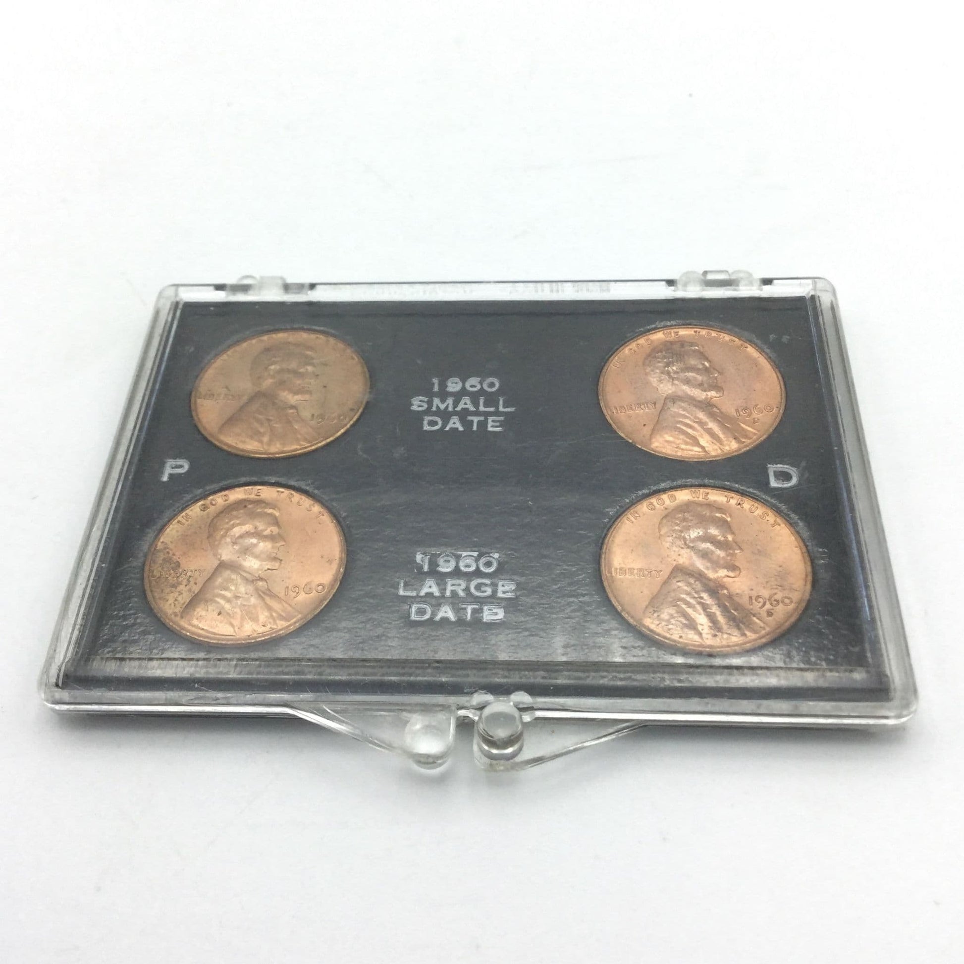 Set of four pennies in a display case on a white background