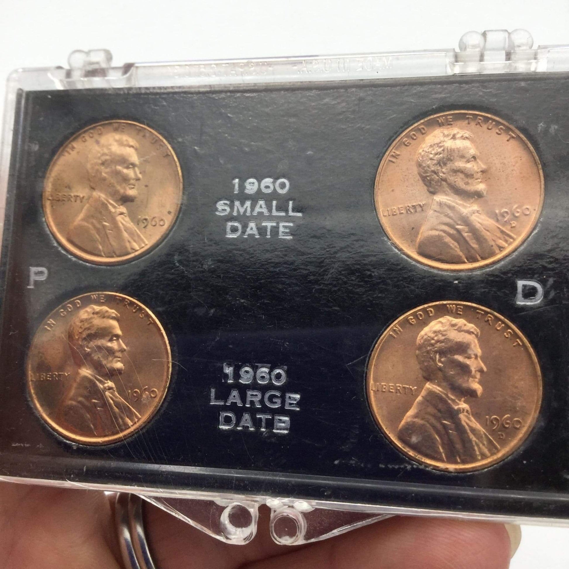 Set of four 1960 Lincoln pennies in a display case.