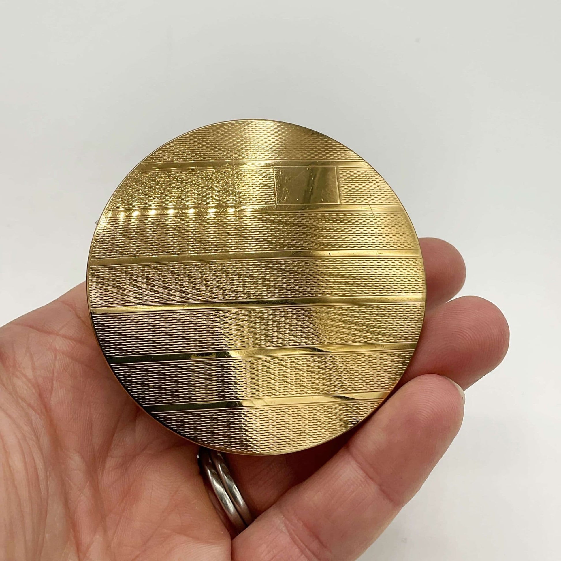 beautiful gold coloured back of mirror held in a hand