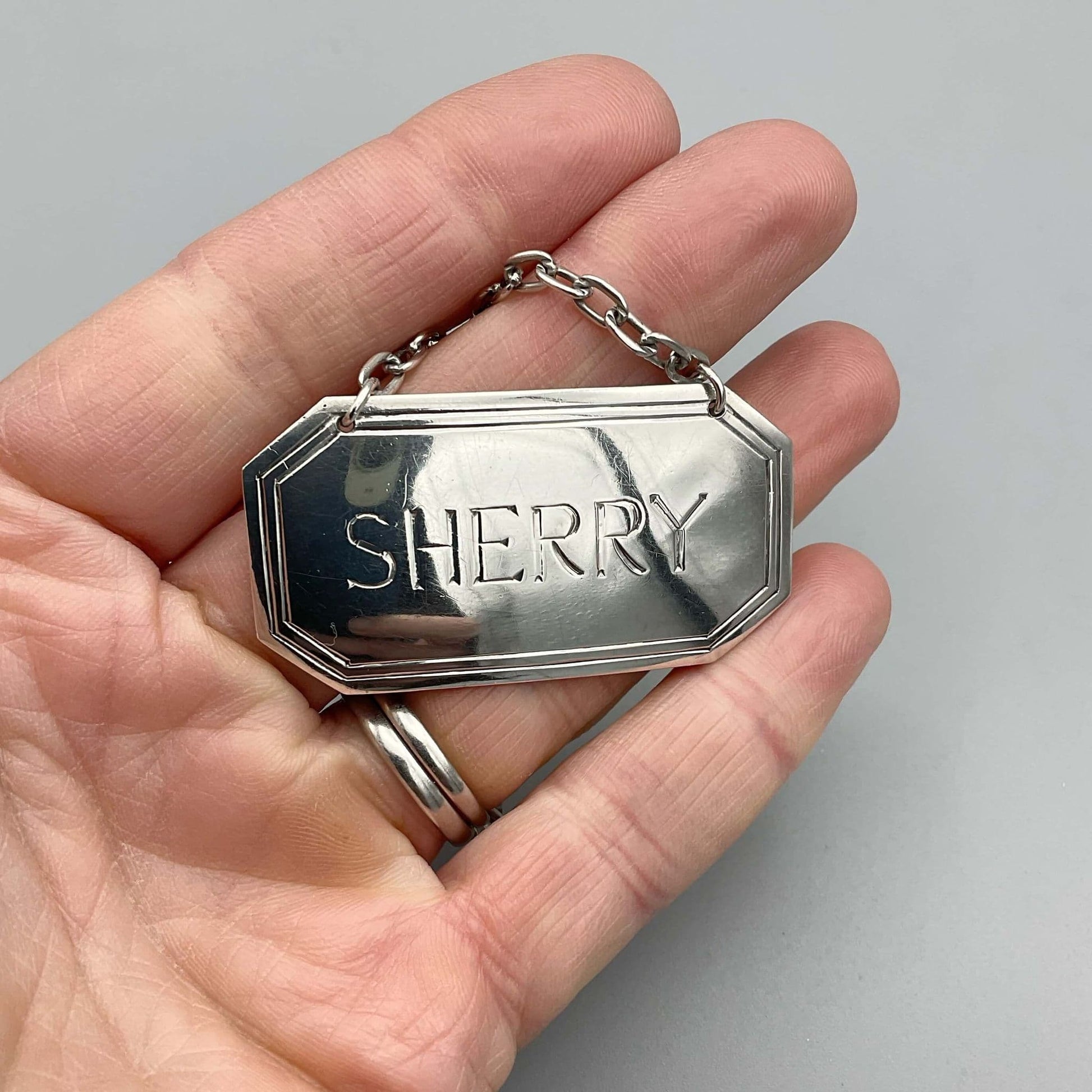 Silver Sherry decanter label held in a hand