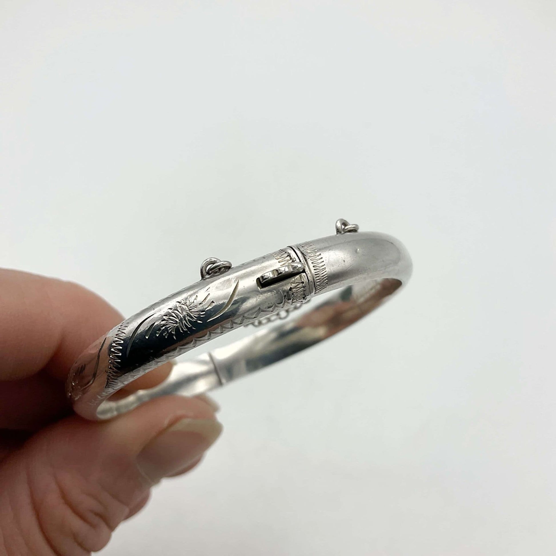 clasp on silver bracelet held in a hand