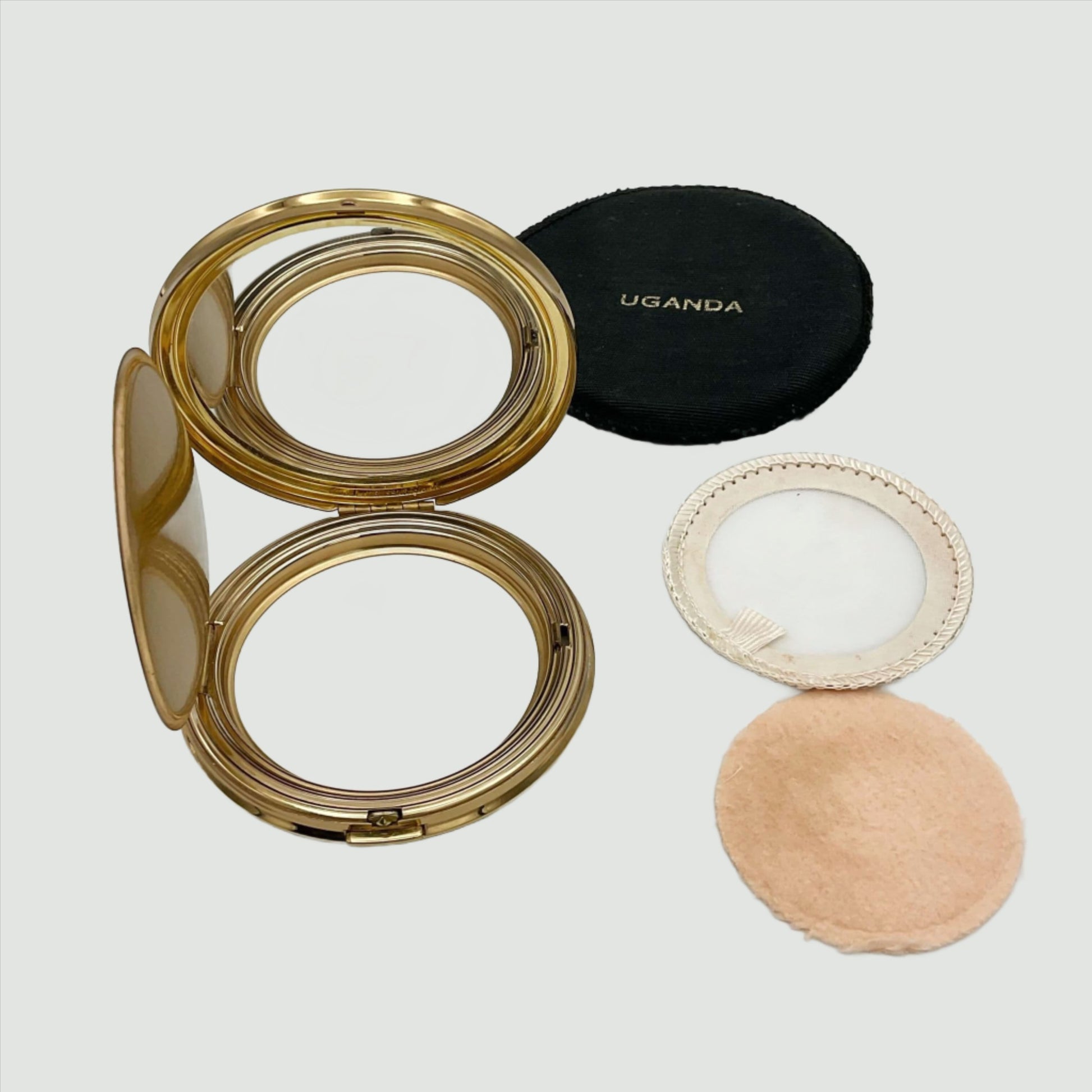 open powder compact case showing a clear mirror, a powder applicator, powder screen and black case