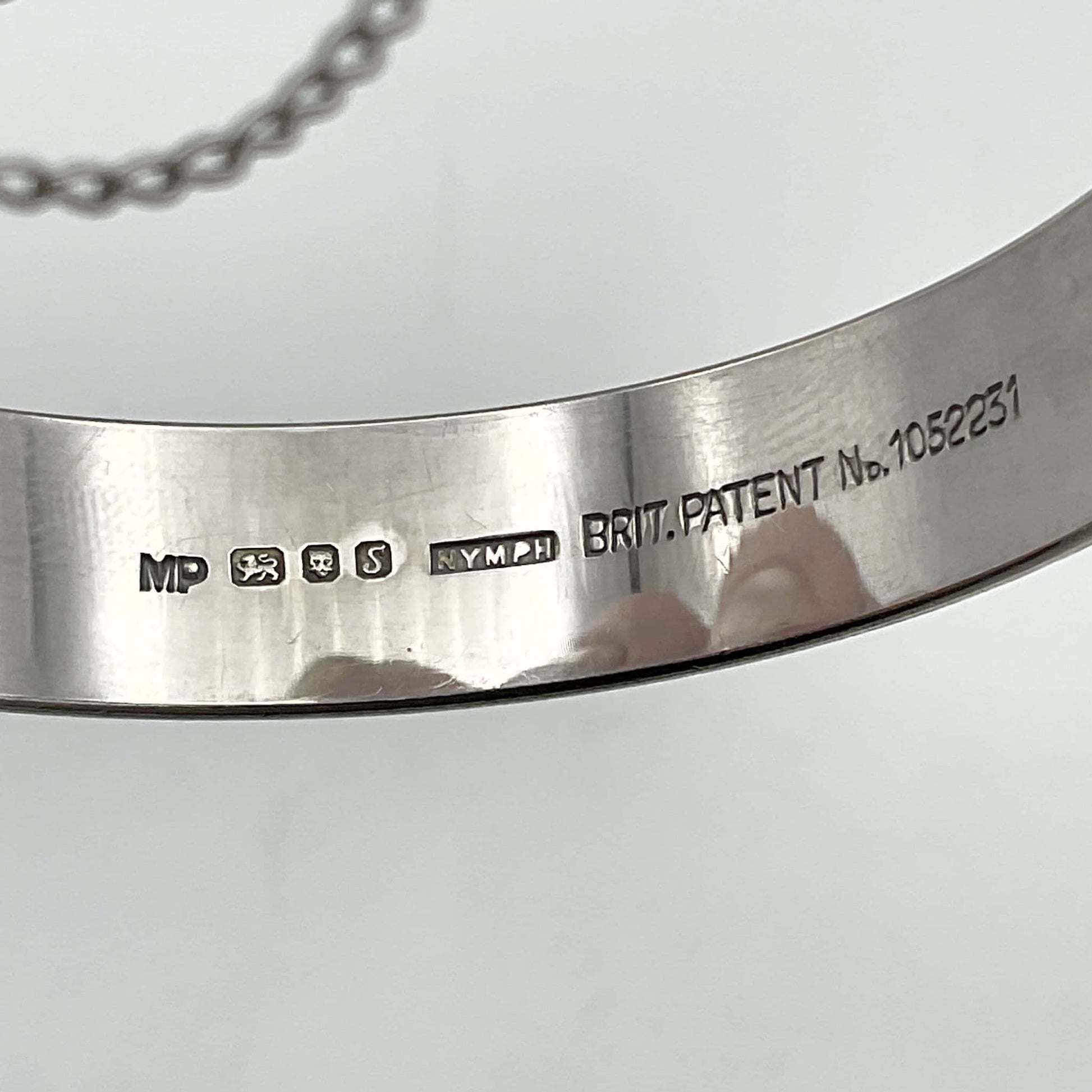 Hallmarks, maker’s mark, Nymph and Brit Patent no 1052231 imprinted on the inside of the bracelet 