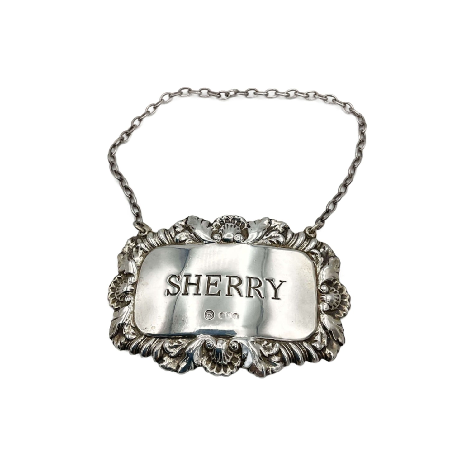Ornate silver decanter label with Sherry engraved in the centre on a white background