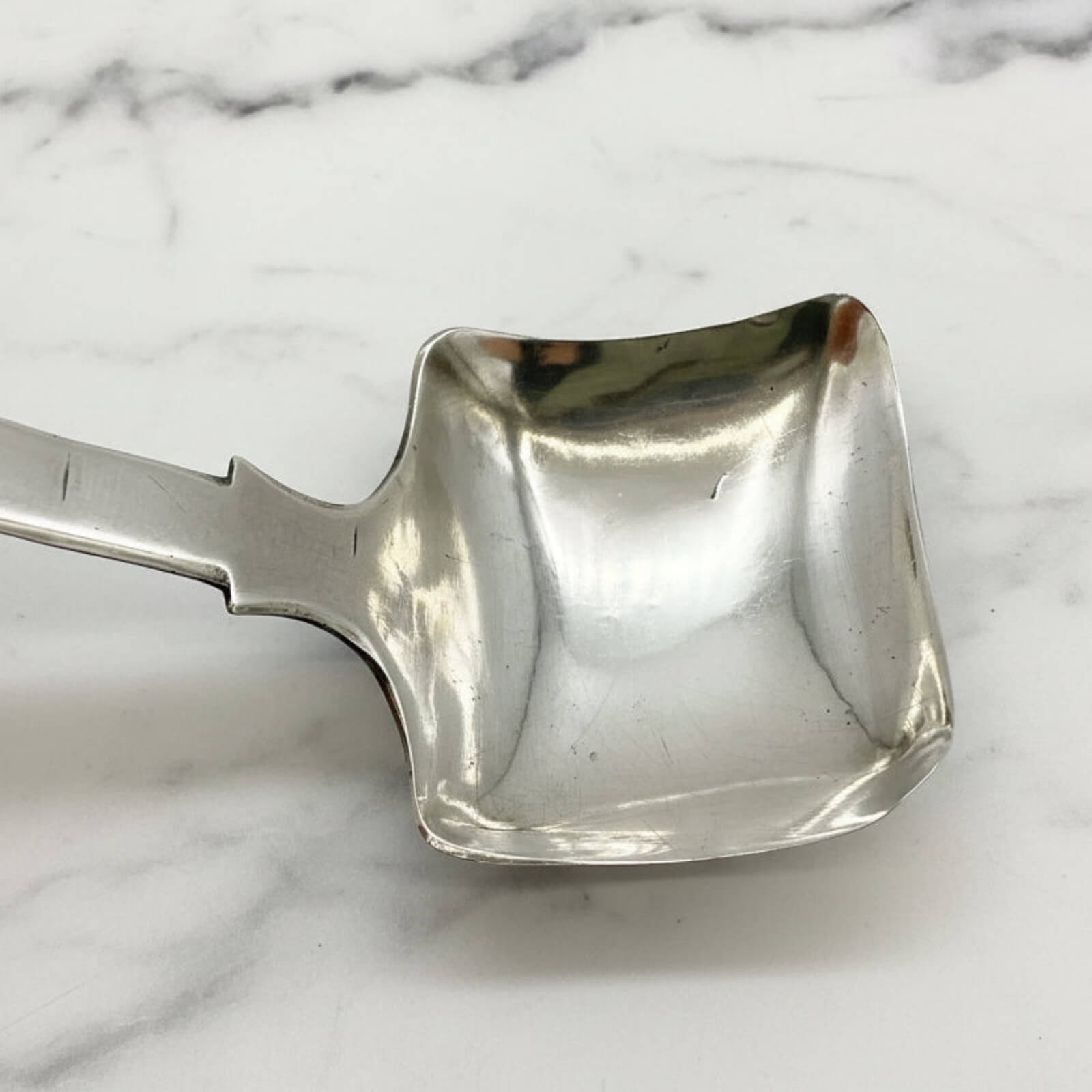 Silver scoop on a marble surface