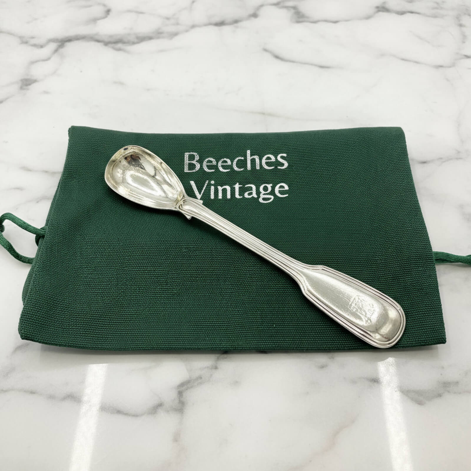 Antique 1835 Sterling Silver Mustard Spoon on a green bagon marble