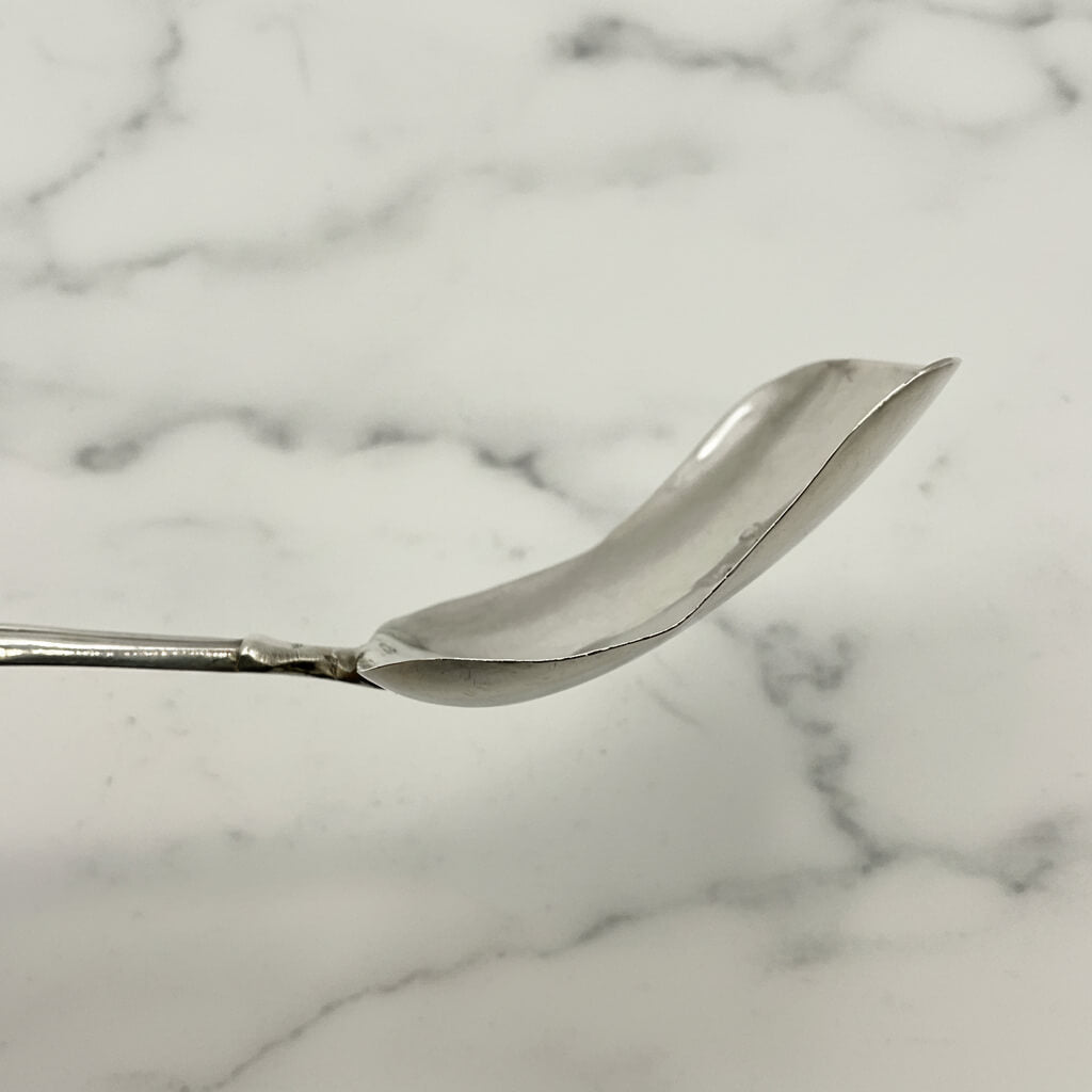 Silver caddy spoon bowl on a marble background