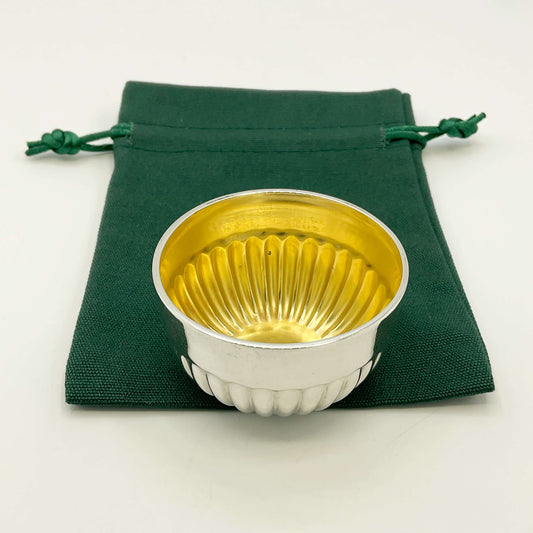 Glided silver Victorian salt on a green gift bag and white background 