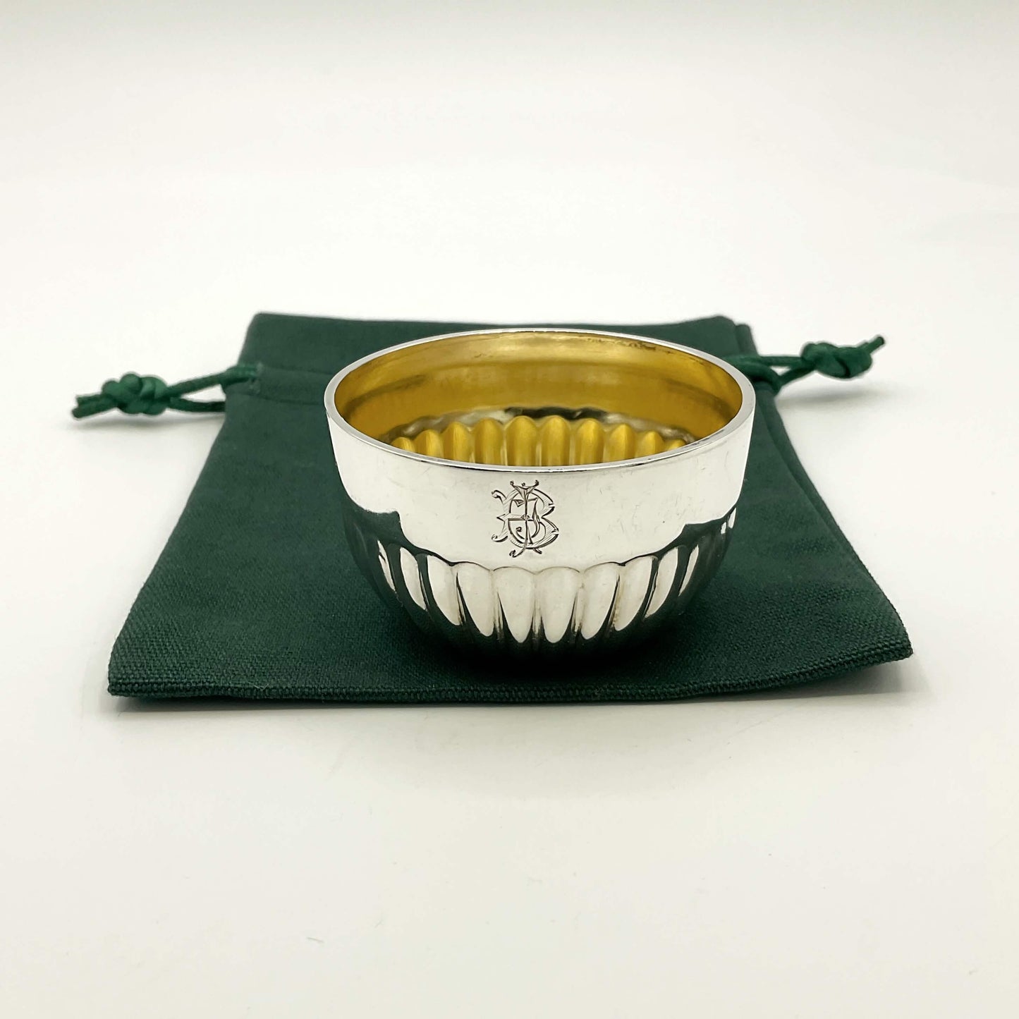 Glided silver Victorian salt on a green gift bag and white background 