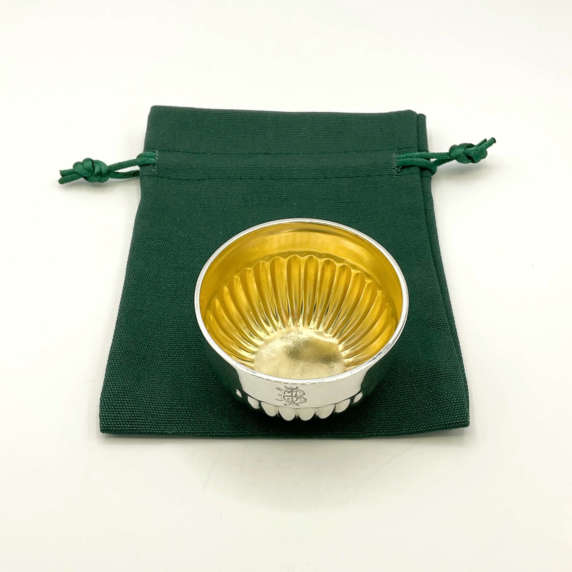 Glided silver Victorian salt on a green gift bag and white background 