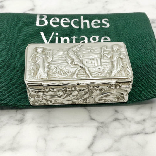 Decorative silver box on a green fabric pouch with 'Beeches Vintage' branding on a marble surface.