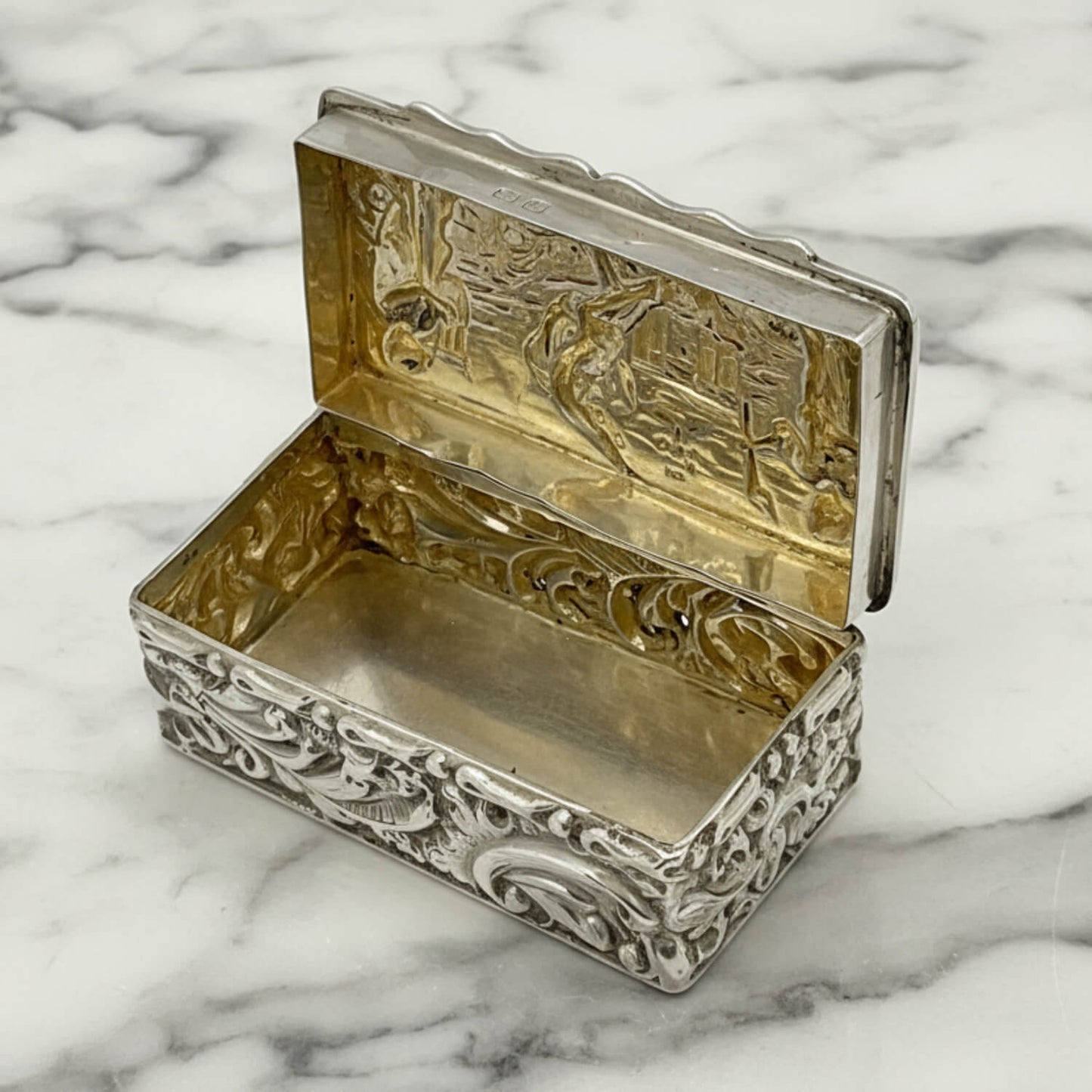 Decorative silver and gold box on a marble surface