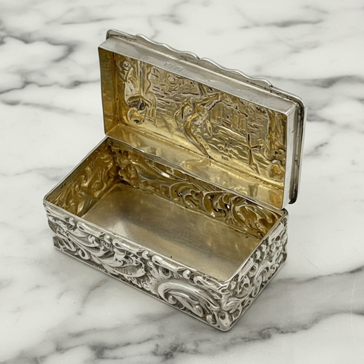 Decorative silver and gold box on a marble surface